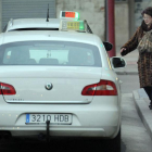 Una mujer coge un taxi en una de las paradas de la ciudad.-ISRAEL L. MURILLO
