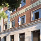 El emblema de Hogar Social Madrid ondea en una de las ventanas del nuevo edificio okupado, las antiguas oficinas de la Editorial Aguilar. /-PERIODICO