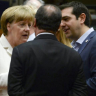 El primer ministro griego, Alexis Tsipras (dcha) habla con la canciller alemana Angela Merkel (izda) y el presidente francés François Hollande (c) durante la reunión del Eurogrupo en Bruselas.-Foto: EFE