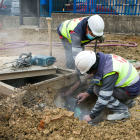 Dos obreros trabajan en la remodelación de la calle Valle de Mena en el polígono de Villalonquéjar. TOMÁS ALONSO