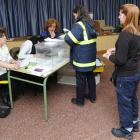 Una empleada de Correos deposita los votos por correo en una de las mesas electorales.-ISRAEL L. MURILLO