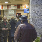 Clientes hacen cola en ‘El Gato Negro’ con el cartel al fondo del premio repartido.-ISRAEL L. MURILLO