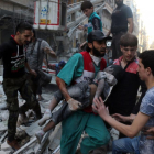 Un hombre saca el cadáver de un niño de una casa alcanzada por un bombardeo en Alepo.-AMEER ALHALBI / AFP