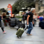 Una pareja con sus maletas y mochilas, ayer en una calle de Barcelona.-FERRAN NADEU