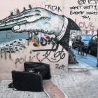 Un hombre pasa ante un grafiti de denuncia en la ciudad de Atenas, este lunes.-Foto: EL PERIÓDICO