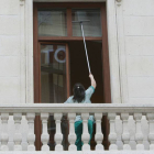 Una trabajadora limpia las ventanas de un edificio.-RAÚL OCHOA