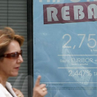 undefinedDos mujeres pasan frente al anuncio sobre hipotecas de una entidad bancaria.