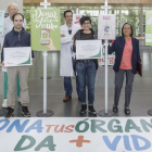 Ganadores, miembros de la asociación y profesionales del HUBU posan junto a los carteles participantes en el hall del hospital.-SANTI OTERO