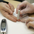 Un sanitario realiza la prueba de medición de glucosa a un paciente.-SANTI OTERO