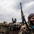 Un soldado turco frente a una columna de tanques en la frontera con Siria.-AFP / BULENT KILIC