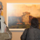 Santiago Alonso Sagredo posa en primer plano mientras unas señoras observan una fotografía de Castroverde de Campos (Zamora).-Israel L. Murillo