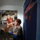 Mayra Alpízar posa junto a un retrato de su padre y ‘El salto’, un bordado de su trabajo feminista.-Raúl Ochoa