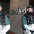 Agentes de la Guardia Civil custodian la sede de la empresa pública Aguas de las Cuencas Mediterráneas (Acuamed), en Madrid, durante el registro de las dependencias.-EFE / VÍCTOR LERENA