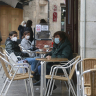 Unas personas sentadas en una terraza recientemente abierta.