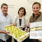 Juan José Gandía, Consuelo García y Borja Suárez posan con una caja de manzanas y el cartel de la feria.-RAÚL G. OCHOA