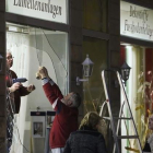 Unos hombres reparan los escaparates de una tienda rotos por los manifestantes ultraderechistas en Leipzig.-AFP / JAN WOITAS