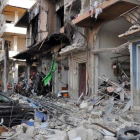 Coches y edificios destruidos cerca del lugar de un doble atentado con bomba en Homs, el 21 de febrero.-EFE