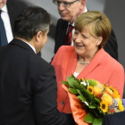 Merkel, felicitada con flores por su 61 aniversario por el vicecanciller, Sigmar Gabriel, en el Bundestag, este viernes.-Foto: AFP / TOBIAS SCHWARZ