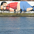 Enorme grafiti de Aylán en la orilla del río que cruza Fráncfort.-AFP / ARNE DEDERT
