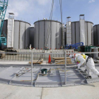 Dos operarios trabajan ante unos tanques de agua de Fukushima.-Foto: REUTERS / TORU HANAI