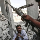Un hombre con un arma incautada el Estado Islámico en Kobane.-AFP PHOTO/YASIN AKGUL