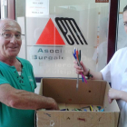 Un voluntario entrega al personal de Asbem parte de los bolígrafos y material de escritura recolectados para la campaña.-ECB