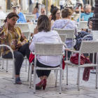 Varias personas disfrutan del buen tiempo en una terraza.-SANTI OTERO