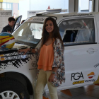 Cristina posa con el coche con el que participó en el certamen. Arriba con las participantes en Doha.-ECB