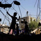 Unos niños palestinos juegan en las ruinas de un edificio destruido.-Foto: AFP/ MOHAMMED ABED