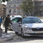 Dos personas mayores con mascarilla abordan sendos taxis en la parada de la plaza del Cid. RAÚL OCHOA