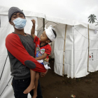 Un padre y su hijo tras ser evacuados a causa de la erupción del volcán Agung.-/ FIRDIA LISNAWATI / AP