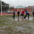 Jugadores y colaboradores delAparejadores RC achican agua antes de concretarse la suspensión del choque, ayer.-ECB