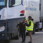 Dos operarias conversan con un transportista en el Centro de Transportes de Burgos.-RAÚL G. OCHOA
