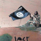 Un militante del Estado islámico ondea una bandera del califato en Raqqa (Siria).-Foto: AP