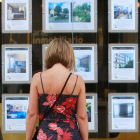 Una mujer mra anuncios en una inmobiliaria de la capital. ECB
