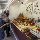 Una señora ojea los productos de un expositor en la Feria del Mimbre de Burgos