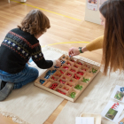 Una maestra desarrolla una actividad con un alumno.