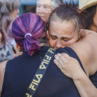 La hermana de la joven se abraza con una mujer en la concentración.