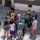 Un grupo de turistas escucha la explicación de una guía de la ciudad.