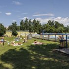 Varias familias disfrutan de la zona de sombra en las piscinas municipales de verano de El Plantío.