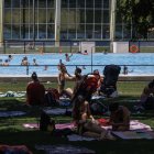 Varias familias disfrutan de la zona de sombra en las piscinas municipales de verano de El Plantío.