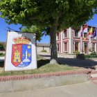 Vista del escudo de la localidad, con el Ayuntamiento al fondo.