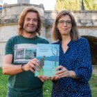 Jairo Marcos y María Ángeles Fernández, con un ejemplar de 'Memorias ahogadas', en el río Arlanzón, junto al puente San Pablo.