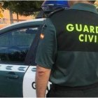 Archivo - Un agente y un coche de la Guardia Civil.