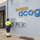 Una operaria de limpieza borra una pintada xenófoba en Burgos Acoge.