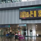 Panel informativo en la estación Rosa Manzano indicando el retraso de un tren en el panel de llegadas.