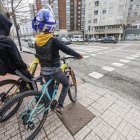 Dos jóvenes, en la avenida Cantabria, esperando a cruzar por un paso ciclista.