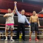 El árbitro levanta el brazo del vencedor del combate.