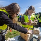 Dos voluntarias construyen una caja nido para pequeñas aves.