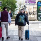 Dos hombres con maletas por el centro de la ciudad de Burgos.